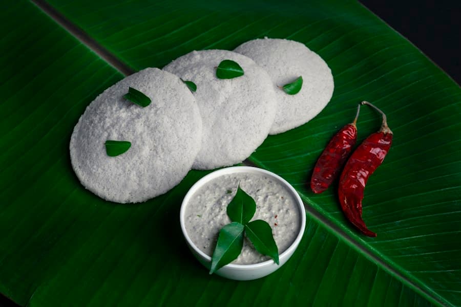 South Indian breakfast of idli with coconut chutney and dried red chillies on a banana leaf