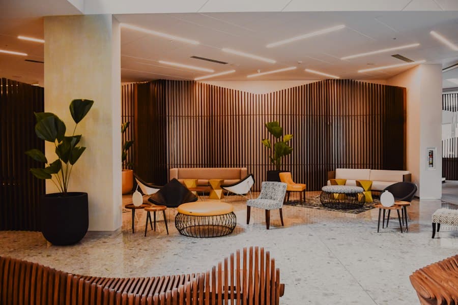 Lobby lounge with low sofas, wood-slat walls, marble floor and potted plants