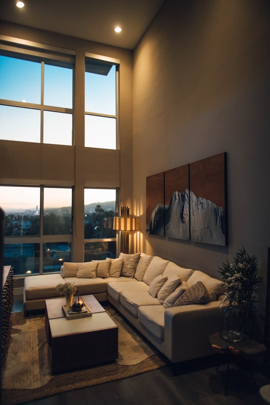 Suite living area with a sectional sofa, coffee table and double-height windows